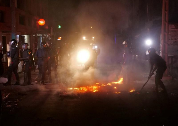 Riot police try to put out fire in the middle of the street during protests