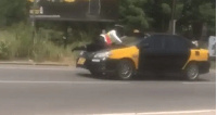 An officer lying on a vehicle bonnet for safety