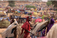 Sudanese girl who fled the conflict in Darfur,moves past shelters near the border of Sudan and Chad