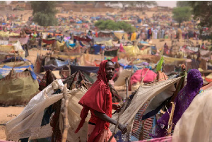 Sudanese girl who fled the conflict in Darfur,moves past shelters near the border of Sudan and Chad