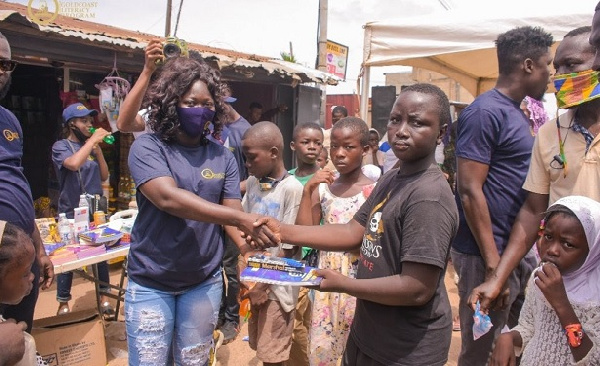 GoldCoast Literary Program founder (in face mask) rewards a child participant