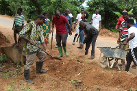 Bismark Tetteh Nyarko fixing the Koforidua Asesewa highway with some community members