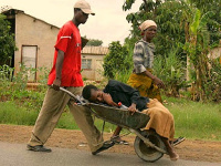 The writer says transporting a sick person in a wheelbarrow throws dust on Africans as non-humans