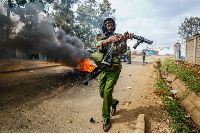 A riot policeman reloads a teargas grenade launcher during clashes with protesters