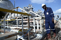 A worker walks by an oil well at the Toma South oil field to Heglig