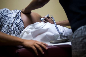 File photo: A pregnant woman being treated by a health officer