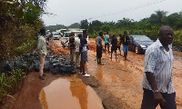 The muddy road on Ewusiejoe section of the Agona-Takoradi highway showing the exposed boulders