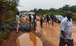 The muddy road on Ewusiejoe section of the Agona-Takoradi highway showing the exposed boulders