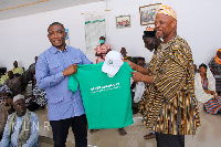 Mireku Duker presenting a Green Ghana shirt to an elder