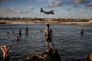 Soldiers enjoying a day off and Somali people look from the beach,  LUIS TATO | AFP