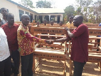 Dr Nana Ayew Afriyie hands over the desks