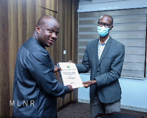 Lands Minister Samuel A. Jinapor receiving the report