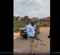 Major Konadu weilding an AK47 assault rifle