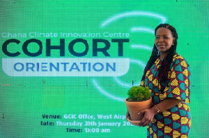 A Cohort 6 entrepreneur holding her plant at the orientation event