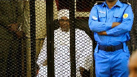 Omar al-Bashir sat in a cage as he was sentenced for corruption