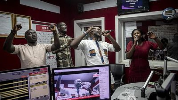 People pray and sing during a worship radio show at Accra FM station in Accra on April 26, 2021