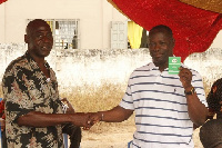 Kofi-Buah receiving his new NDC membership card at a branch meeting