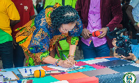 Elizabeth K.T. Sackey signing an agreement