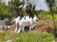 File photo shows health officials burying a victim of coronavirus