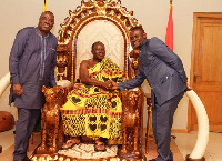 The Asantehene, seated, in a handshake with John Kuma (right) & Awal Mohammed (left)