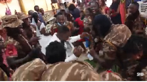 The groom in white suit dancing with his colleagues from the Prison Service