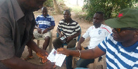 George Kuntu Blankson receiving his party identification card after registering as a member