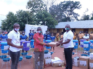 Yussif Amankwa (right) hands over the supplies to Mr. Opoku Donyina (middle)