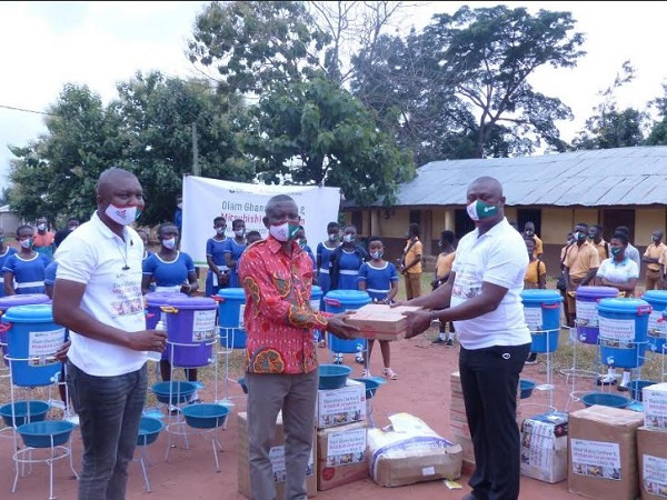 Yussif Amankwa (right) hands over the supplies to Mr. Opoku Donyina (middle)