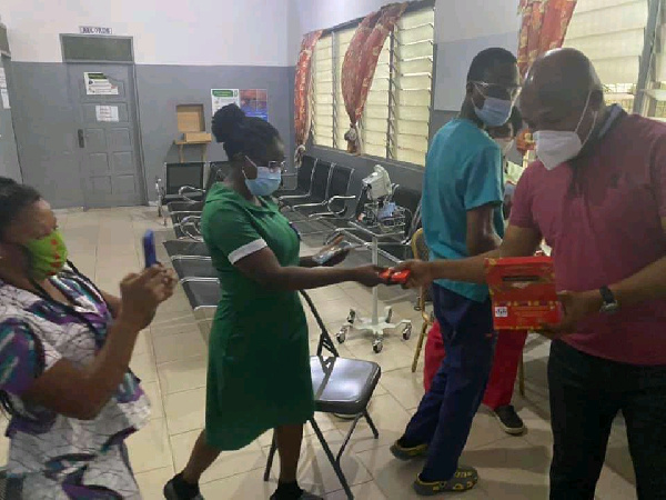 Samuel Okudzeto Ablakwa sharing chocolate to some health workers