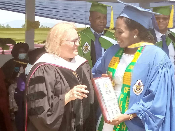 Founder and Board Chair of the Ensign Global College, Mrs. Lynette Gay presenting a plaque