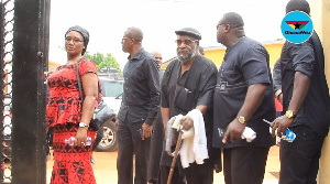 Kojo Dadson in black shades being escorted to the house of late Charles Bucknor's One Week