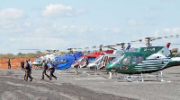 Kenyan government officials arrive in private helicopters at a temporary airstrip