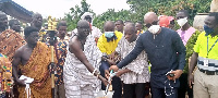 Awulae Amihere Kpanyinli cutting sod for the construction of a culvert bridge