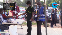 A security officer being issued her ballot