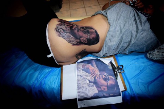 Female fan tattoos Jupitar's face on her waist