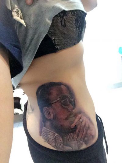 Female fan tattoos Jupitar's face on her waist