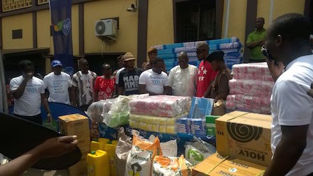 Head of marketing at tigo  with Kwaw presenting items to tthe kumasi central prisons