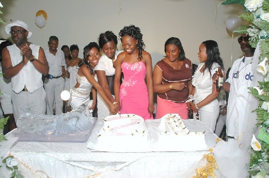 The cutting of the birthday cake assisted by the brain behind the
event; Nana Ama Gyamfi (second left and next to Ellen)