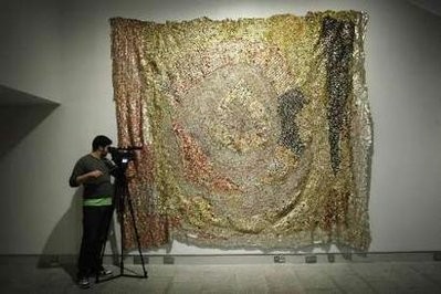 A cameraman films the artwork 