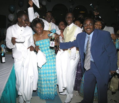 Nana, flanked by her two sons and Friends Club of New Jersey’s President (far right) shows her customized Champaigne bottle.