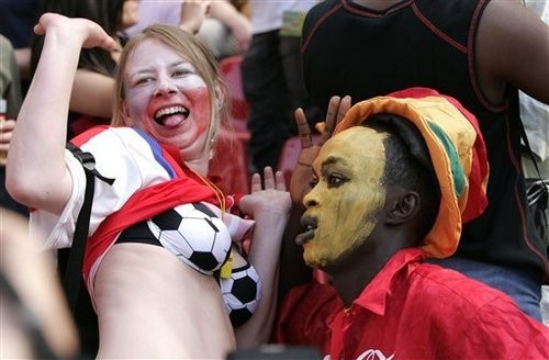 A supporter of he Czech Republic's team, left, sports a bra decorated with a soccer pattern as she jokes with a Ghana's supporter, prior to the World Cup, Group E soccer match between Czech Republic and Ghana, at the Cologne stadium, Germany, Saturday, June 17,