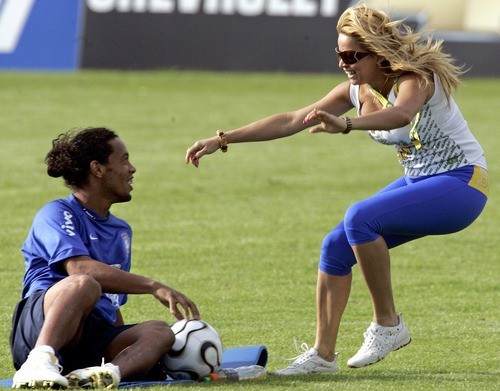 A fan runs onto the pitch to embrace Brazilian striker Ronaldinho (L) during a training session at Thermoplan Arena in Weggis, Switzerland, May 26, 2006