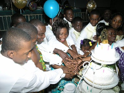 Family and Friends join in cutting the cake