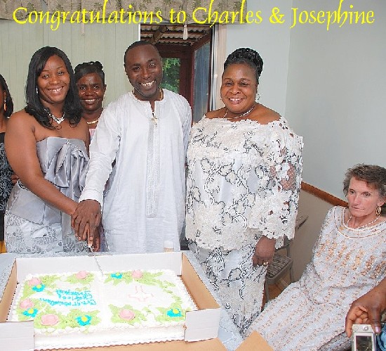 The couple cutting the cake and supported by their respective mothers.