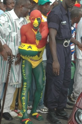 Branded-by- Ghana. One of many unofficial Golden Jubilee mascots poses for a shot and just behind him, Mr. George Aggudey of the CPP tries to find a way. 
<br>Source: myjoyonline