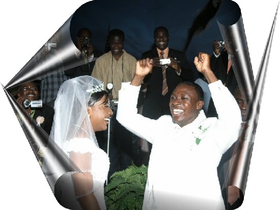 The excited groom (hands raised) unveiled the bride and prepares to kiss her