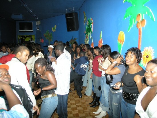 The dancing area of Club Kaneshie as many ladies stand next to the wall enjoying the music