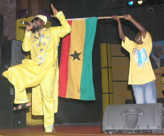 Samini on stage with Ghana flag behind him