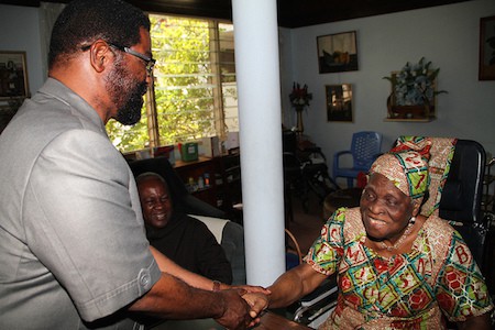 Accra Mayor Alfred Vanderpuije, exchanging greetings with Madam Theodosia Okoh after apology