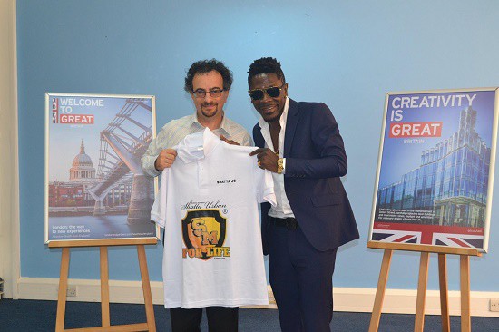 Shatta Wale presents Jon Benjamin with a branded Shatta Movement shirt